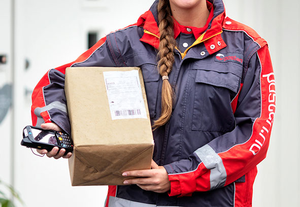 An delivery lady holding a package and a handheld scanner