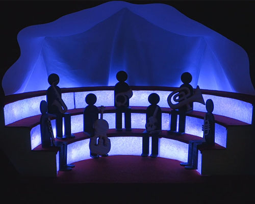 Small silhouettes placed in a miniatyr concert tribune, holding different instruments and a purple back lightning