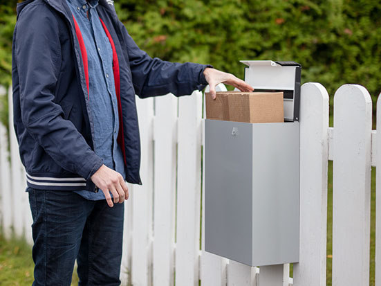 A man picking up a package from their mailbox